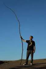 Eric Wong standing on Mount Soledad above La Jolla Shores contemplating a walking stick as a staff of power or a staff to lean upon